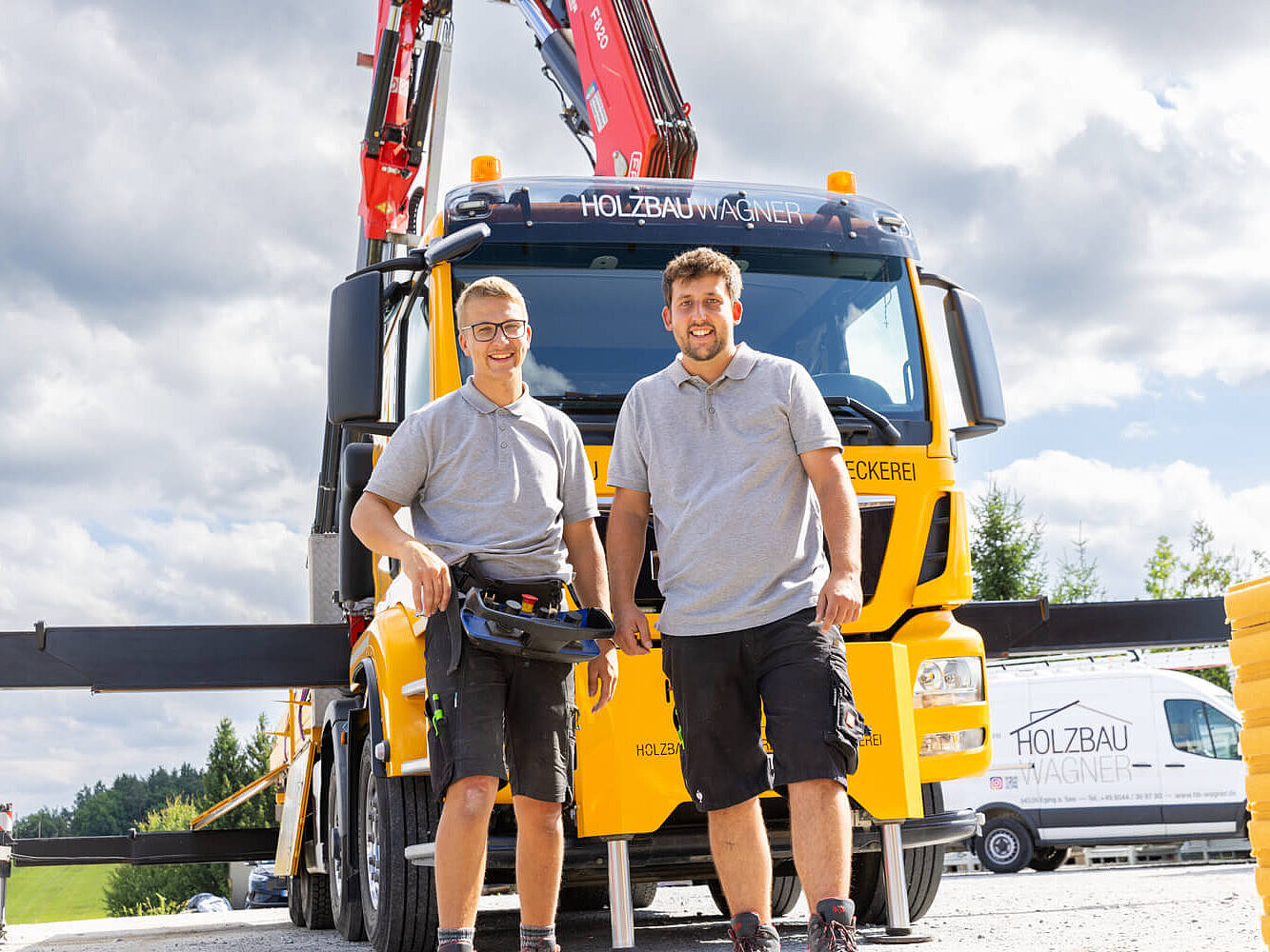 Zwei Holzbau Wagner Mitarbeiter stehen vor einem LKW